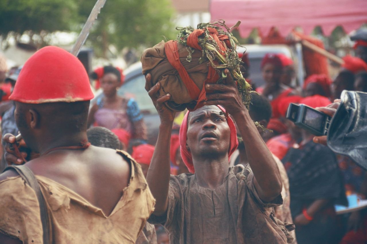 A cultural event in Ghana featuring a traditional ritual with people gathered in vibrant attire.